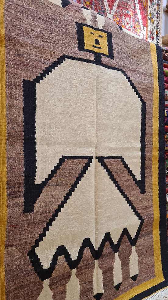 Abstract figurative handwoven rug from Uşak, blending traditional and modern design in earthy tones.