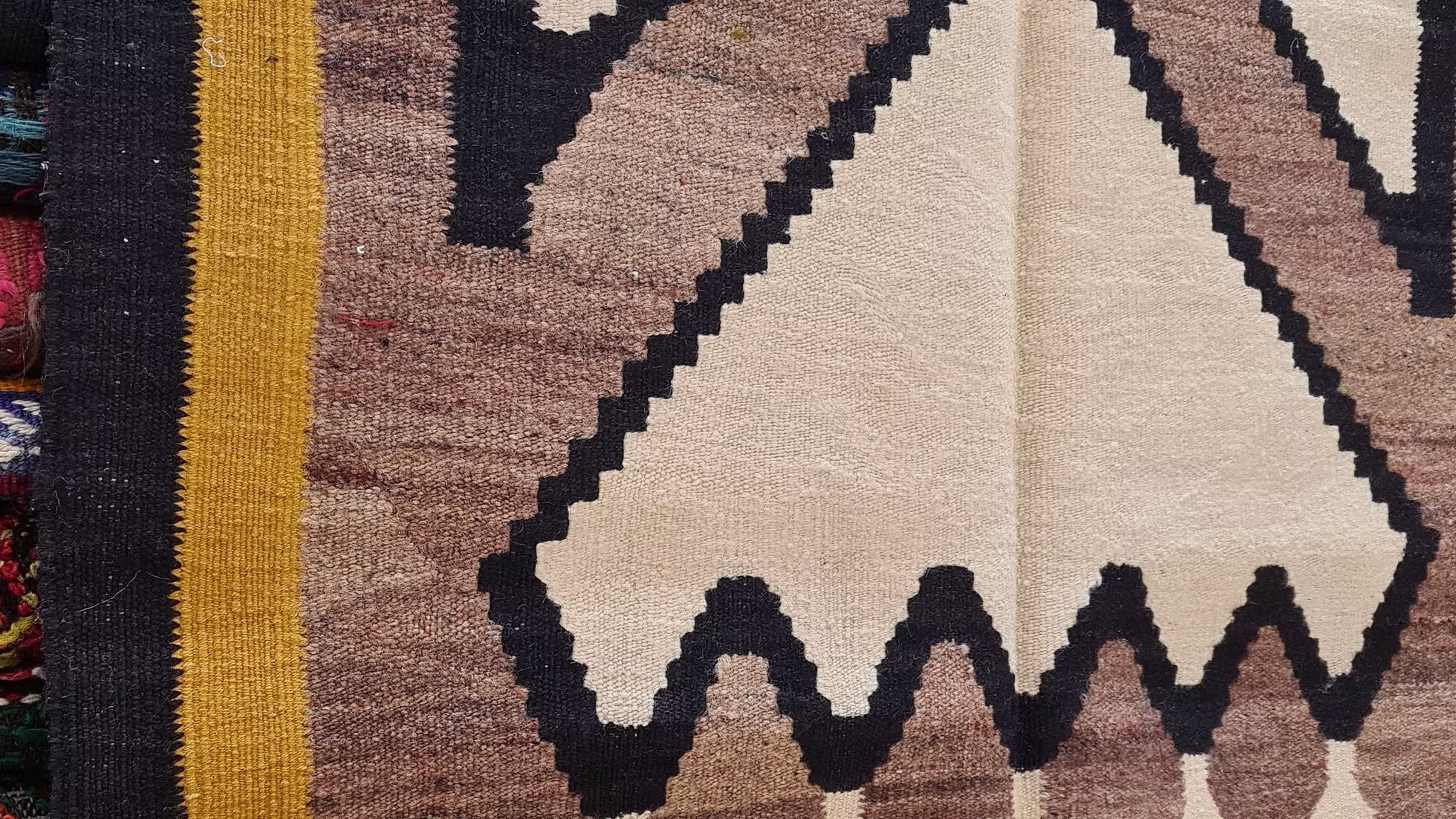 Modern minimalist flat-woven small area rug with tribal motifs.