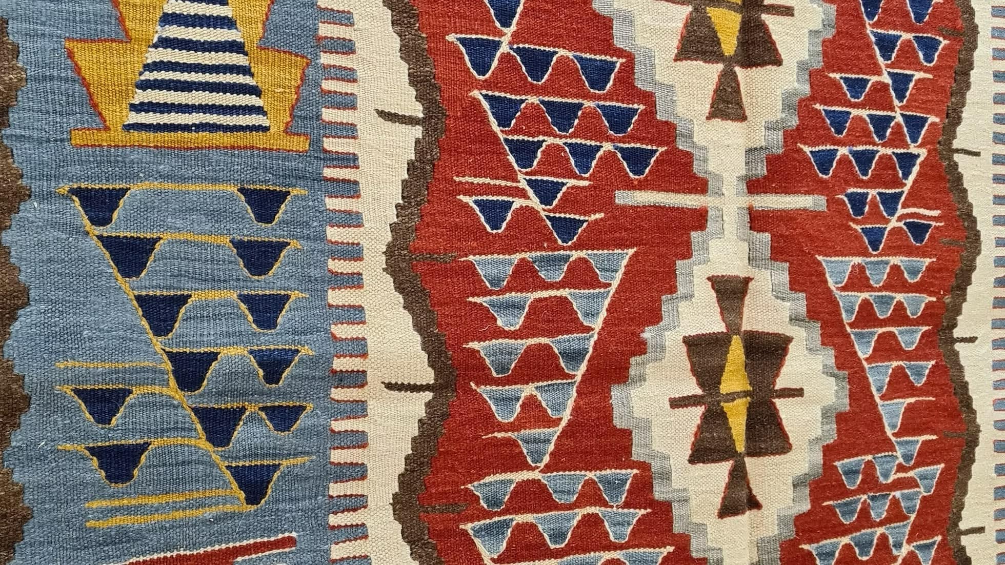 Close-up of a luxury 4x6 Turkish handwoven kilim rug with geometric design and warm vintage-inspired colors for eclectic or mid-century interiors.