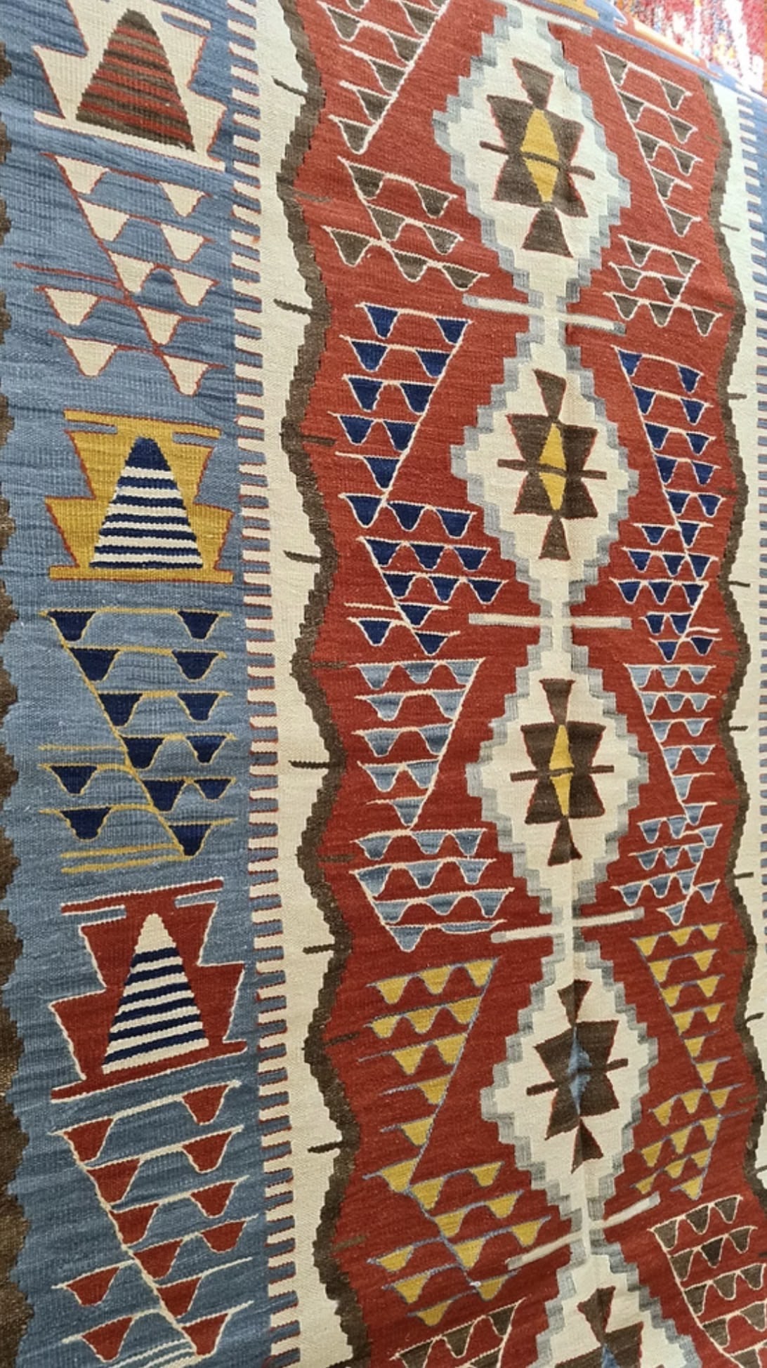Close-up of a luxury 4x6 Turkish handwoven kilim rug with geometric design and warm vintage-inspired colors for eclectic or mid-century interiors.