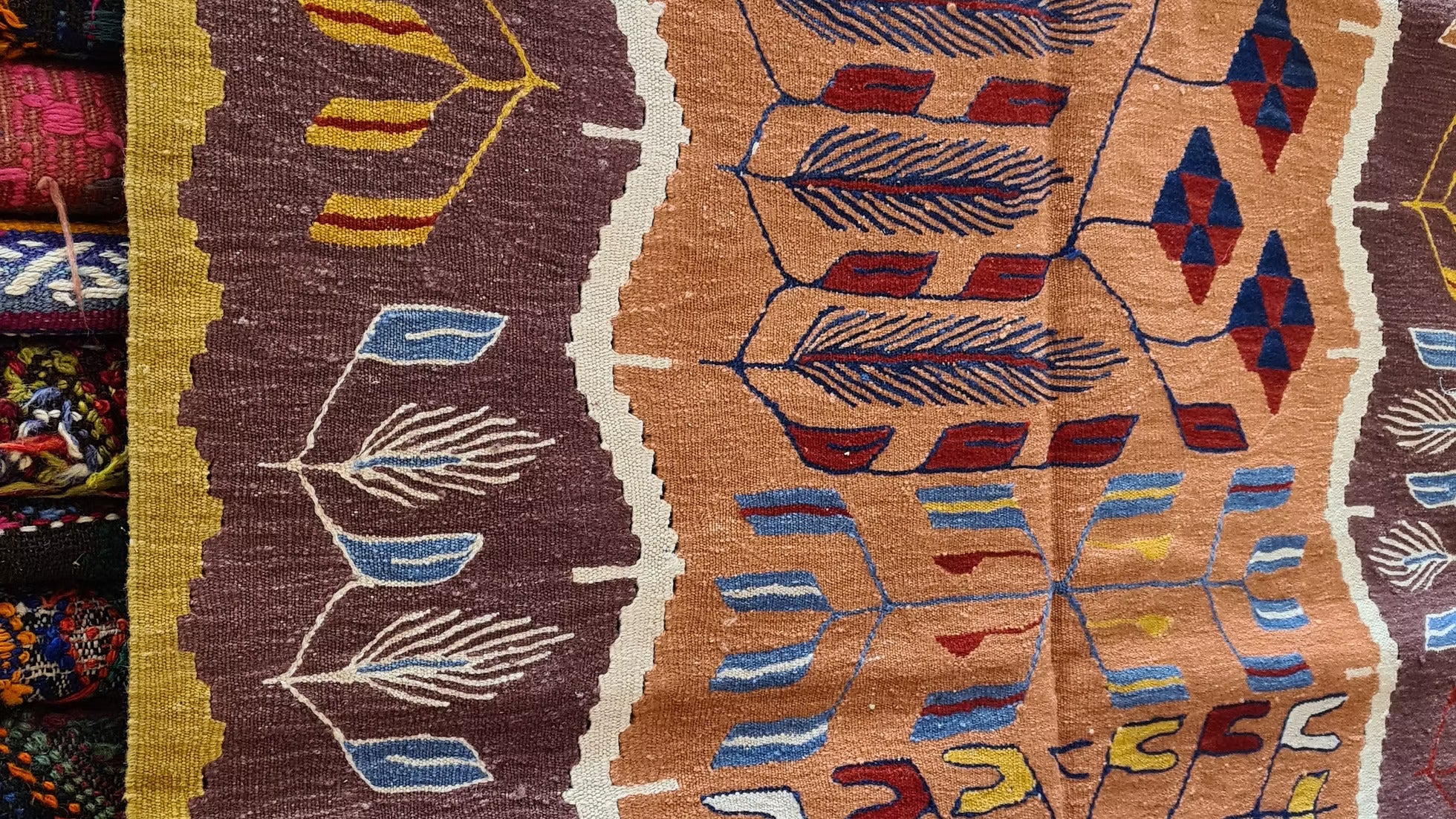 Handwoven Oushak tulip design kilim in warm saffron and walnut tones, perfect as a layered accent rug for curated spaces and modern interiors.