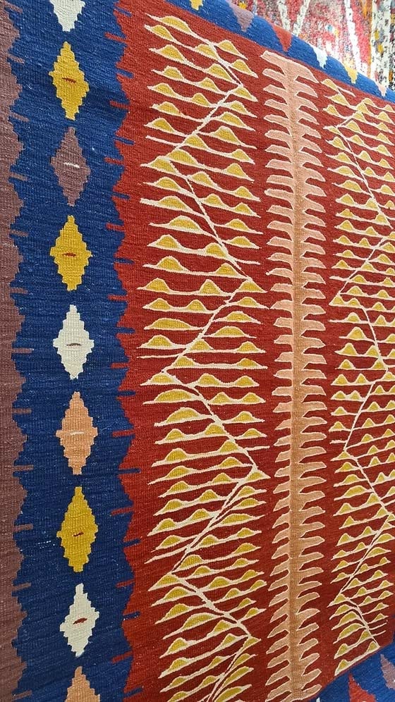 Turkish textile kilim with geometric patterns in blue, red, and yellow.