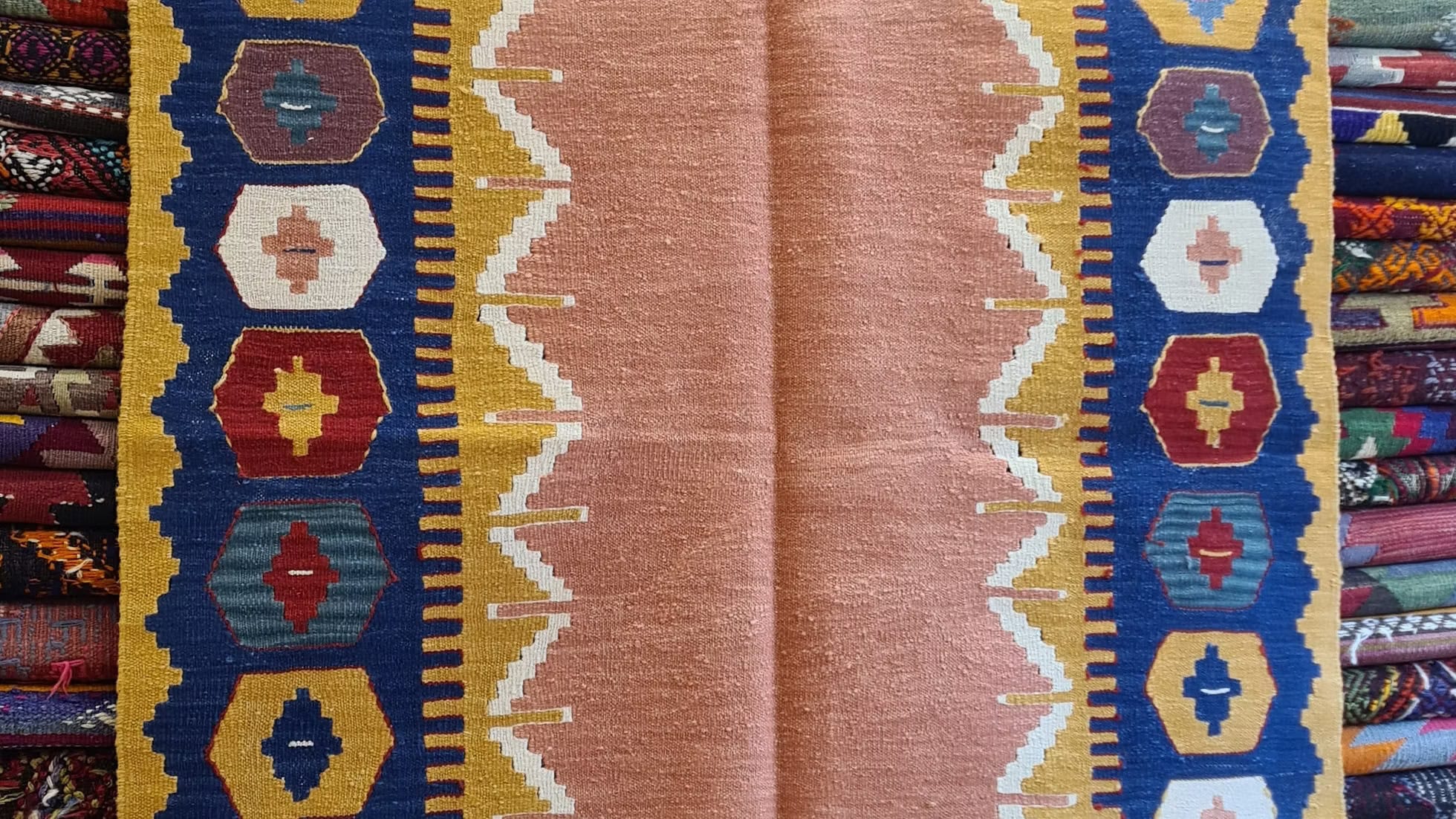 Modern handwoven Turkish kilim rug from Usak with salmon-toned field and minimalist tribal borders