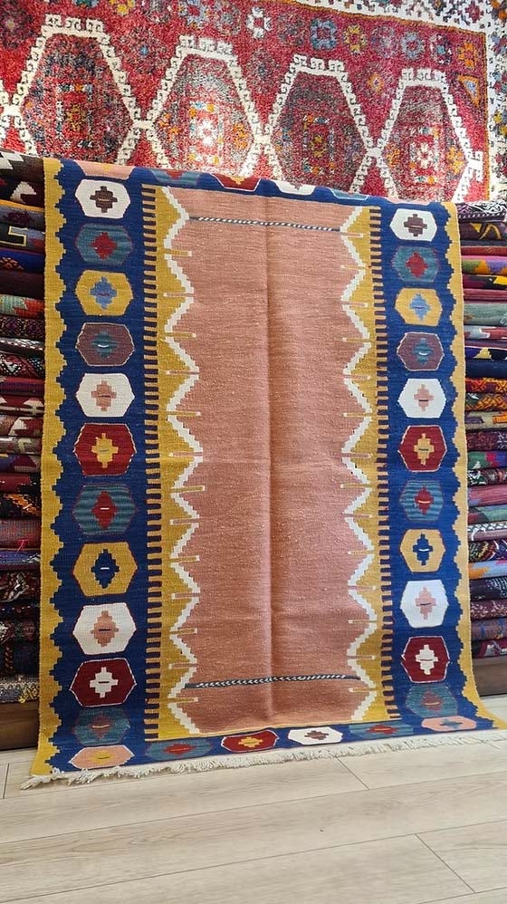 Modern handwoven Turkish kilim rug from Usak with salmon-toned field and minimalist tribal borders