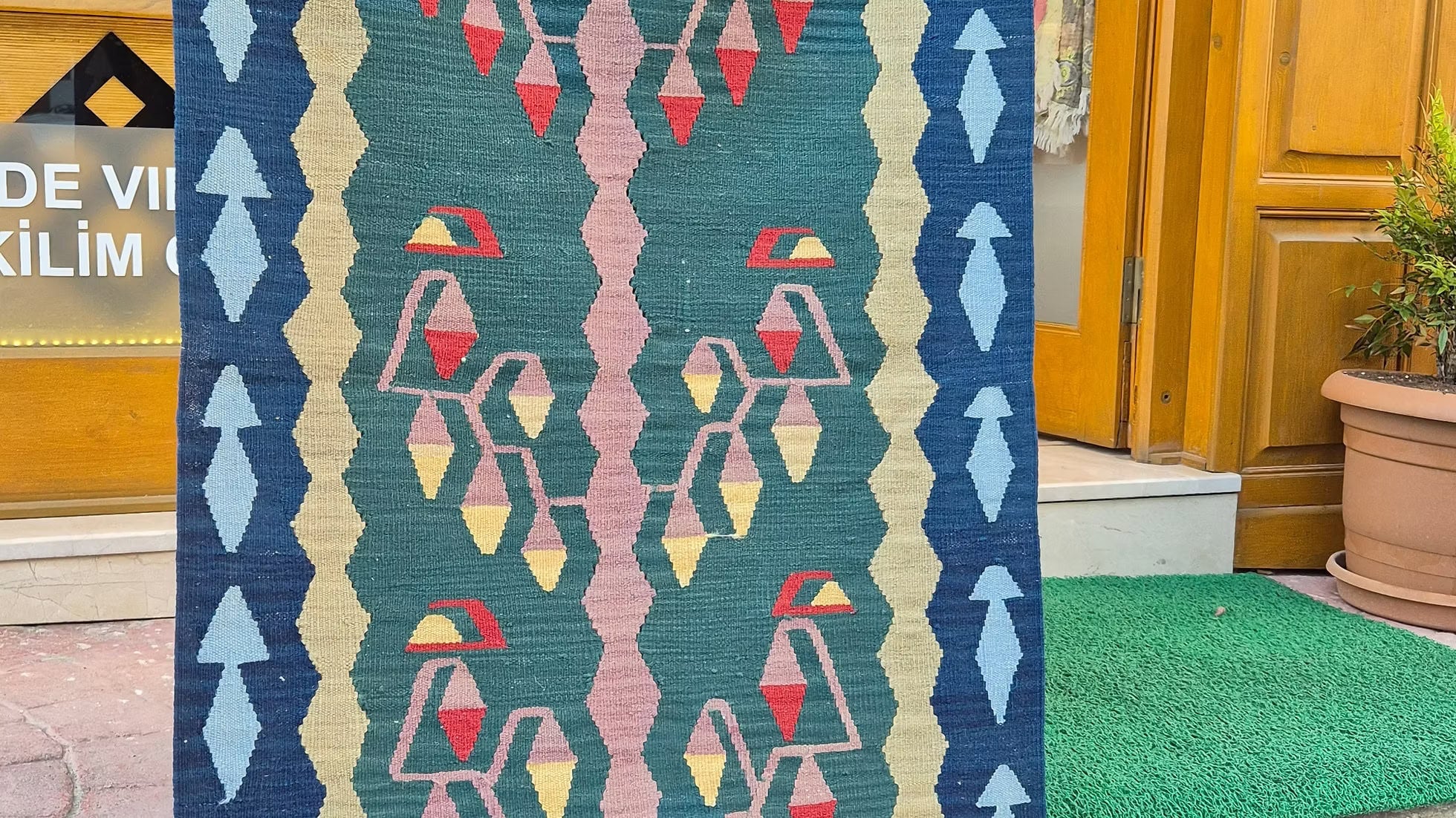 Close-up of Anatolian “Life-of-Tree” motif on pastel salmon pink and burnt sienna kilim runner