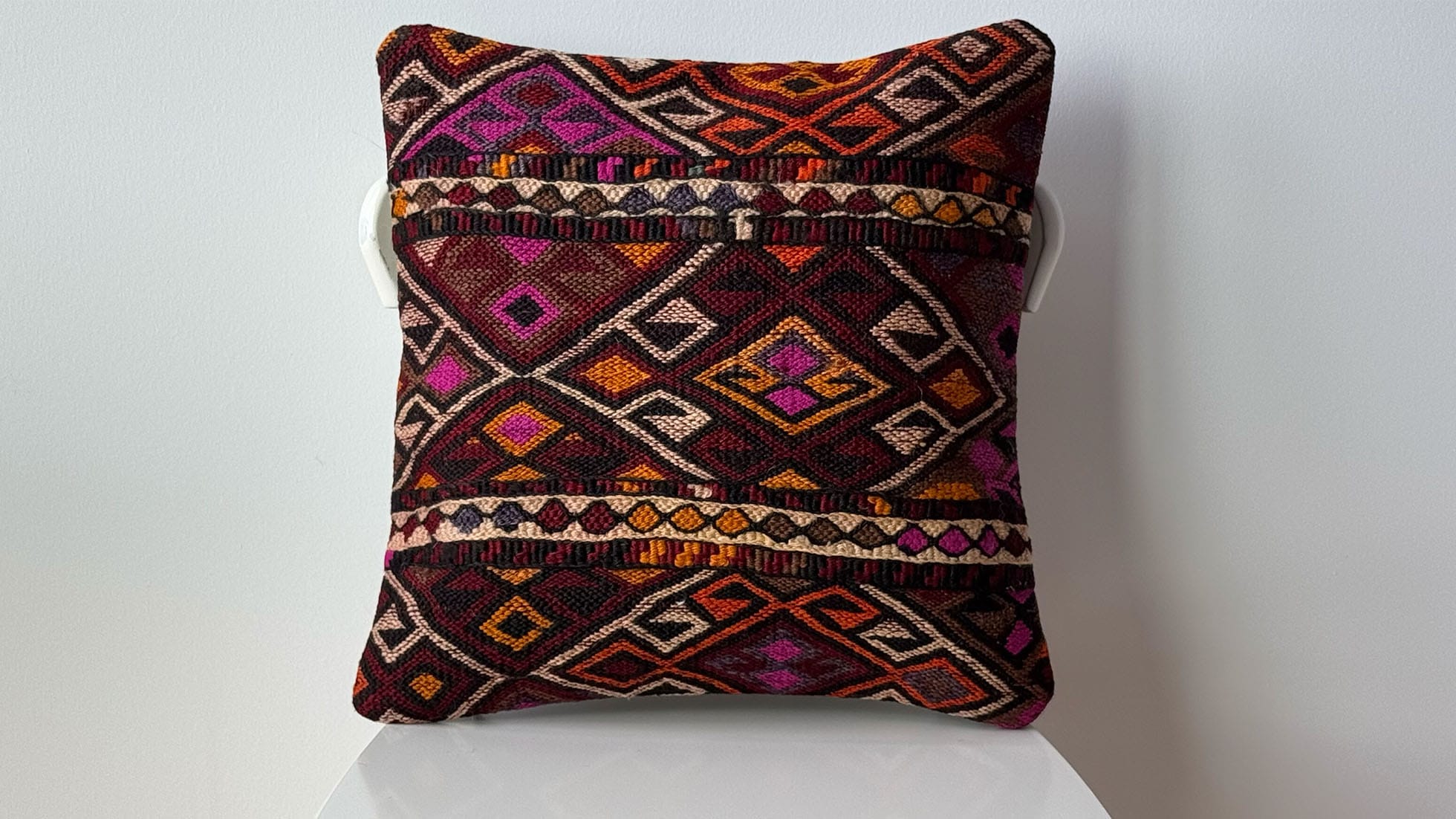 Vintage Turkish kilim pillow 16x16, handwoven with intricate tribal patterns in deep plum, burnt orange, and rich magenta. Perfect for boho, eclectic, and rustic décor styles, this artisan-made throw pillow adds a unique, authentic touch to any living room or bedroom.