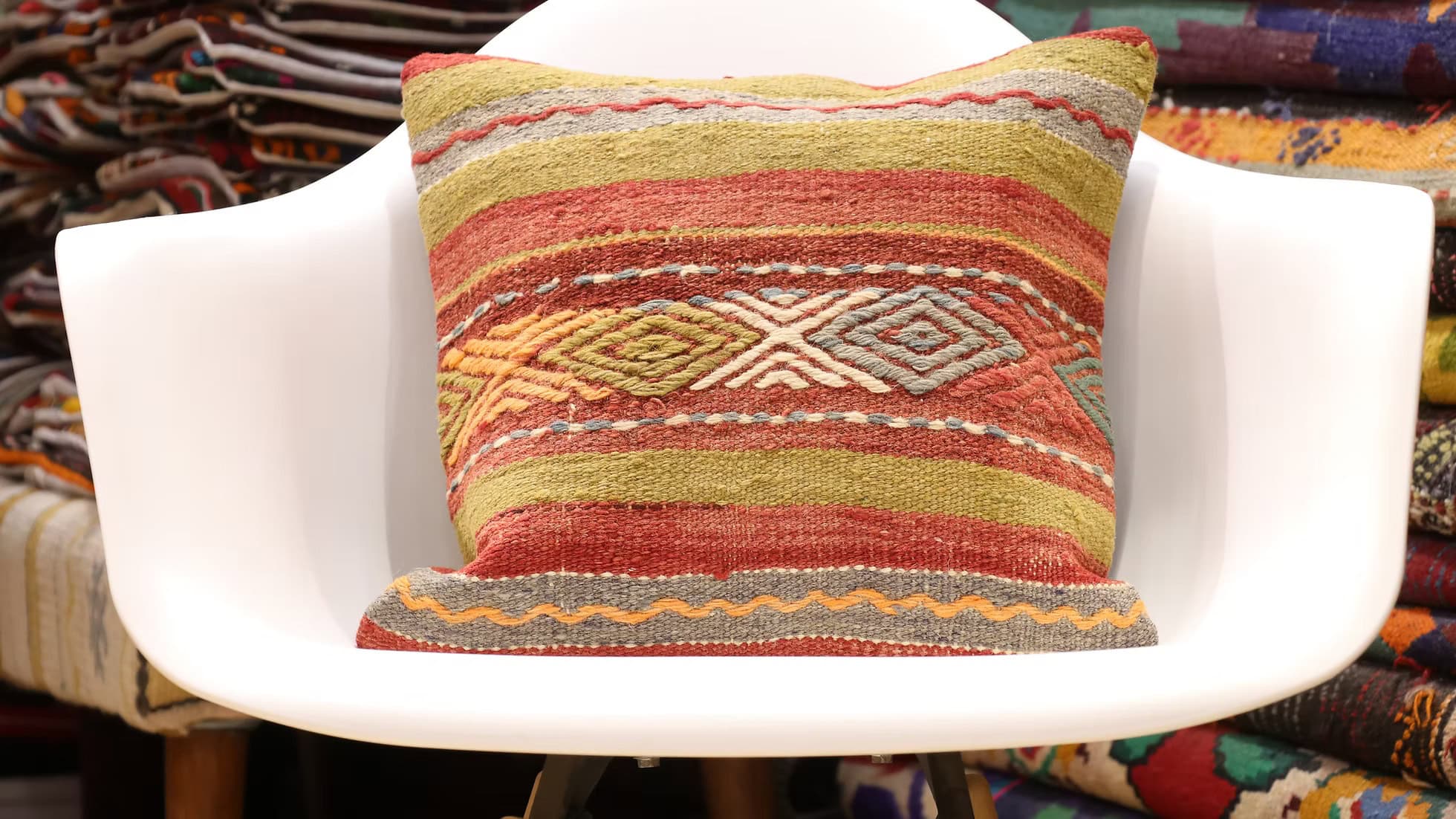 Vintage handwoven kilim pillow cover with olive, terracotta, ivory, and peach colors featuring tribal geometric motifs.