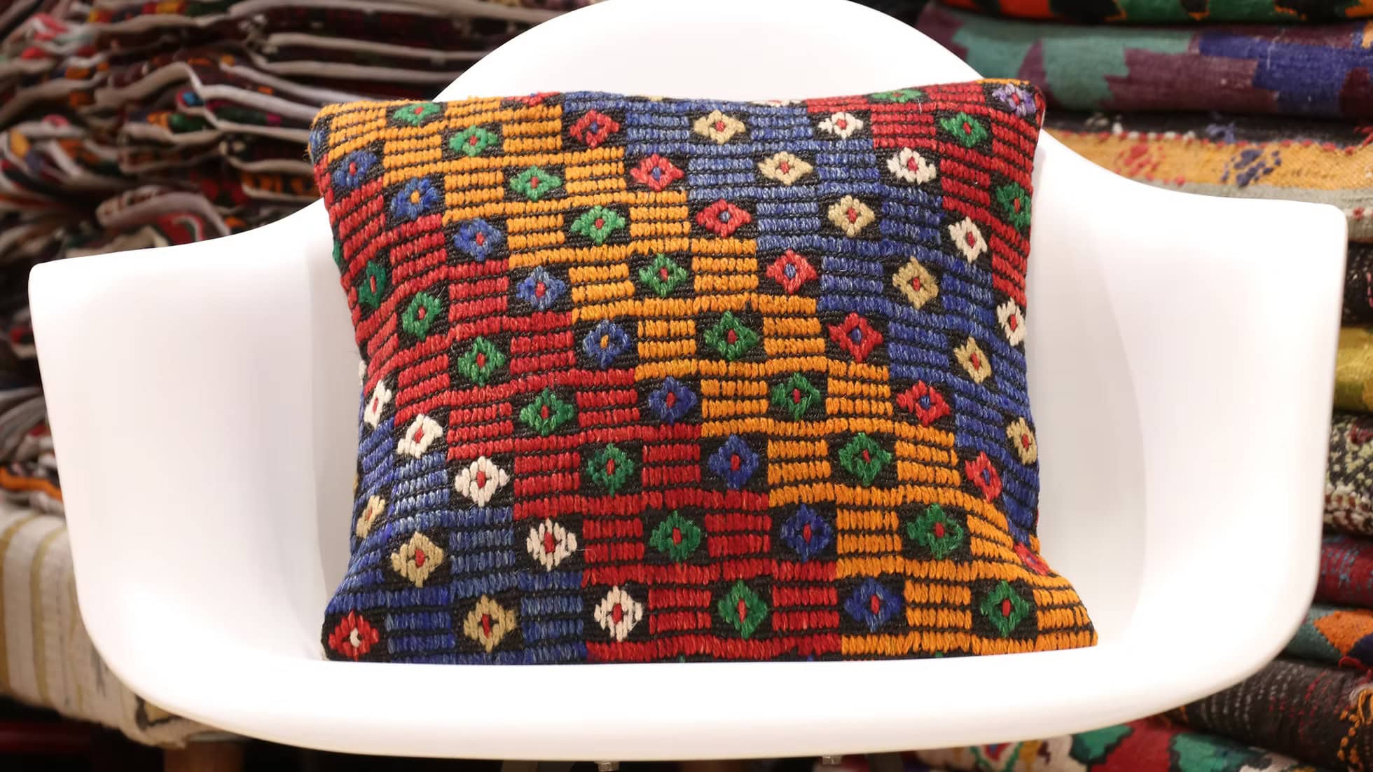 Handwoven vintage kilim throw pillow by Kilim Couture New York, featuring intricate cecim detailing in sun-kissed clementine, celestial denim, umber clay, and evergreen noir. Perfect for rustic interiors.
