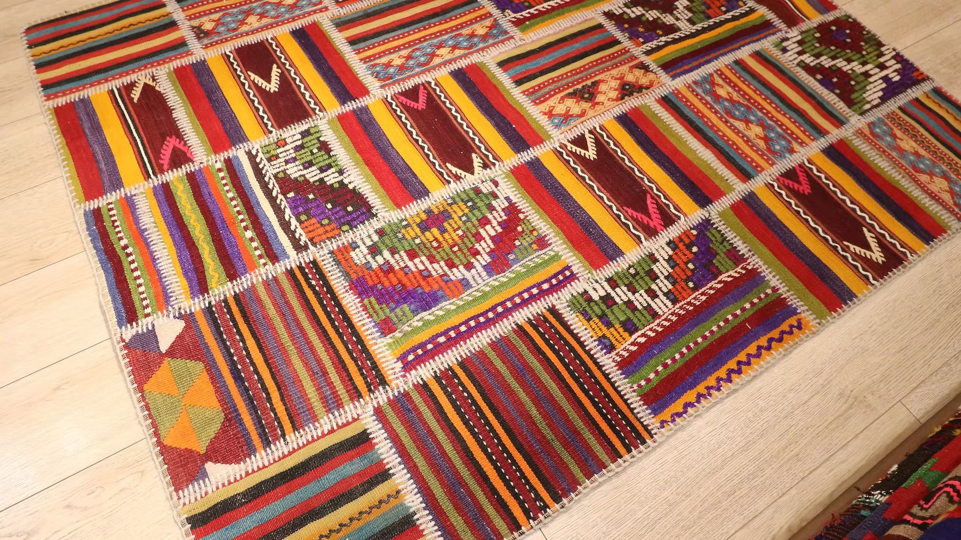 Close-Up of Vintage Patchwork Kilim Rug, Featuring Wool and Tribal Motifs in Bold Colors