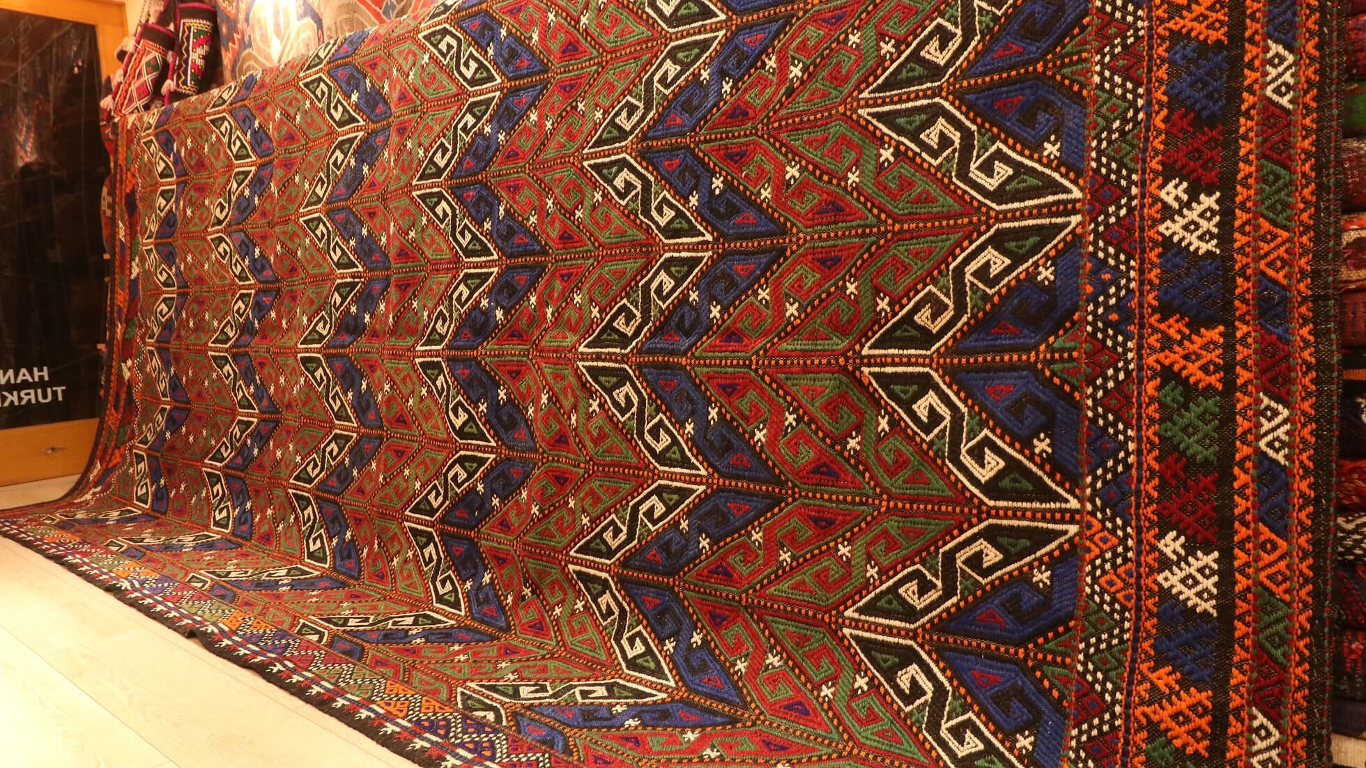 a beautiful yet precious room-sized oversize tribal Turkish rug in faded rustic tones featuring traditional Turkish motifs