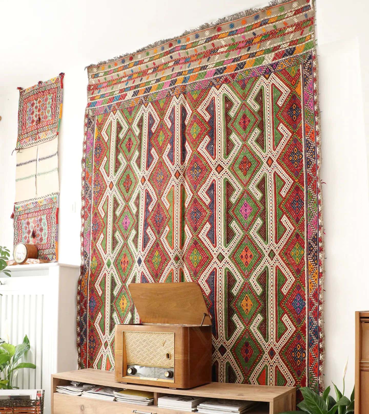 vintage bohemian hand-knotted Turkish wool rug in multicolors hanging on the wall gracefully as a tapestry