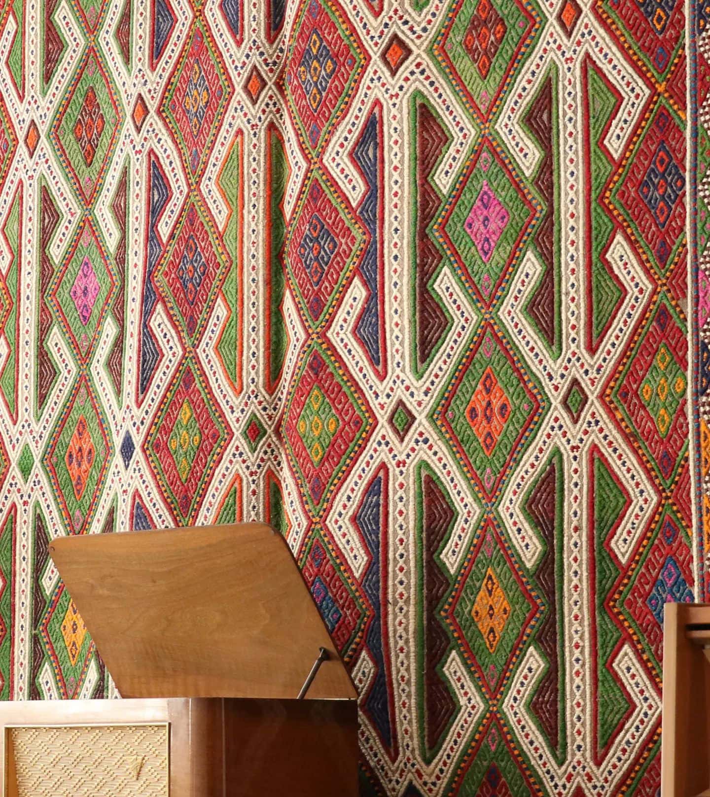 vintage bohemian hand-knotted Turkish wool rug in multicolors hanging on the wall gracefully as a tapestry