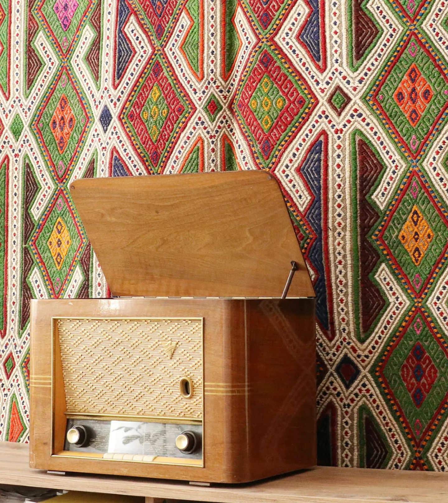 vintage bohemian hand-knotted Turkish wool rug in multicolors hanging on the wall gracefully as a tapestry