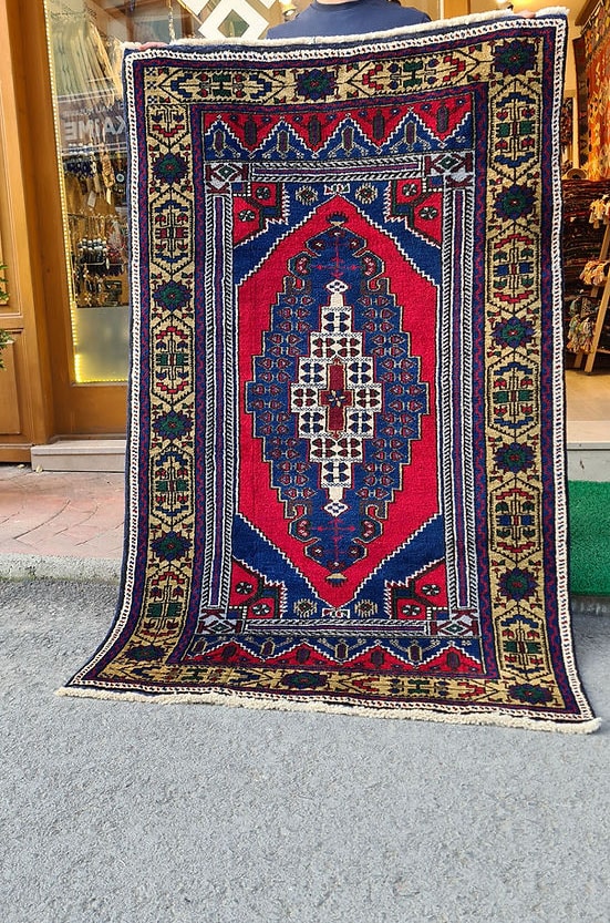 Hand-knotted in Taspinar, Turkey, this semi-antique 4x6 ft rug features a striking medallion with intricate floral patterns in crimson, gold, and azure. Made from pure wool and dyed with natural pigments, it offers unmatched durability and elegance. Perfect for hallways, entryways, or kitchens, this rug blends Anatolian heritage with timeless design.