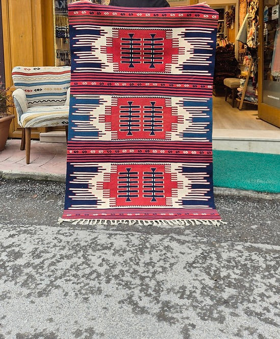 Navajo-style Southwestern flat-weave rug in madder red, indigo navy, and soft oat tones