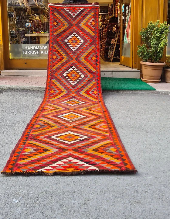 Artisan-made Afghan runner, 3x12 ft, featuring a bold diamond flat-weave design in vermilion red, persimmon orange, and ochre yellow. Durable and versatile, ideal for hallways, kitchens, or entryways, blending tradition with modern style.