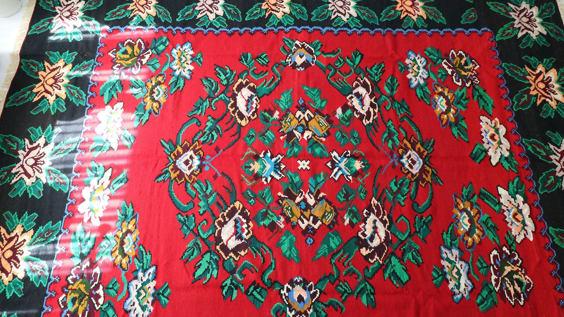 Vintage Bessarabian Rug, 9x11 ft. A handwoven mid-20th-century Romanian masterpiece, featuring a rich oriental red background with five opulent floral bouquets in cream, blue, orange, and red. This timeless European flat-weave rug blends Turkish, Persian, and Western influences, making it a striking statement piece for classic and eclectic interiors.