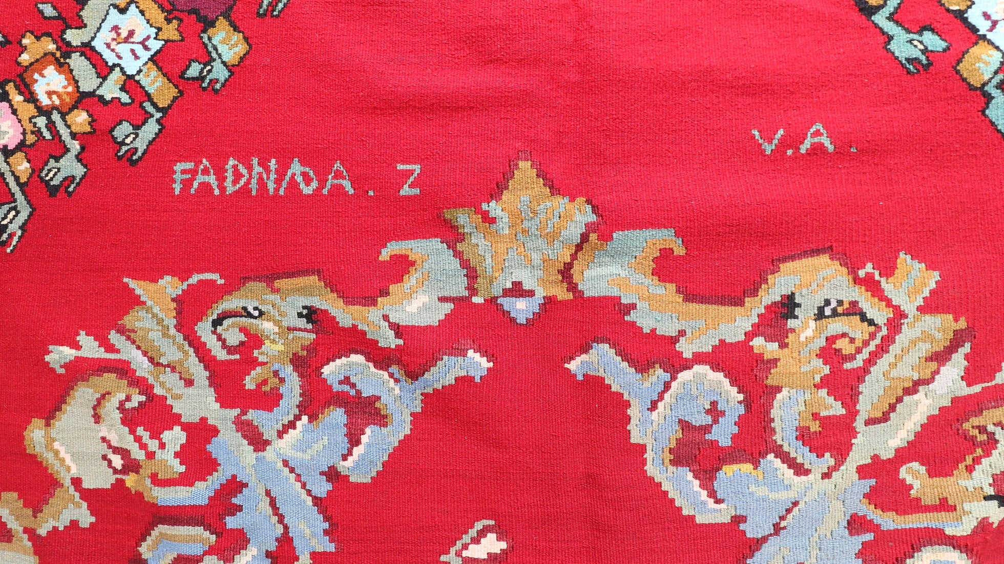 zoomed signature of the weaver on the Vintage Handwoven Bessarabian Kilim Rug in red shades with floral design