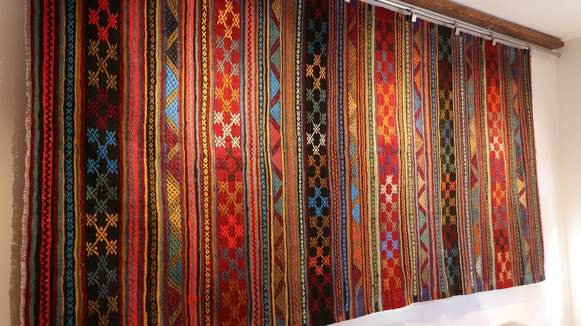 vintage rustic syle handwoven Turkish flat-weave rug in earthy tones on the wall