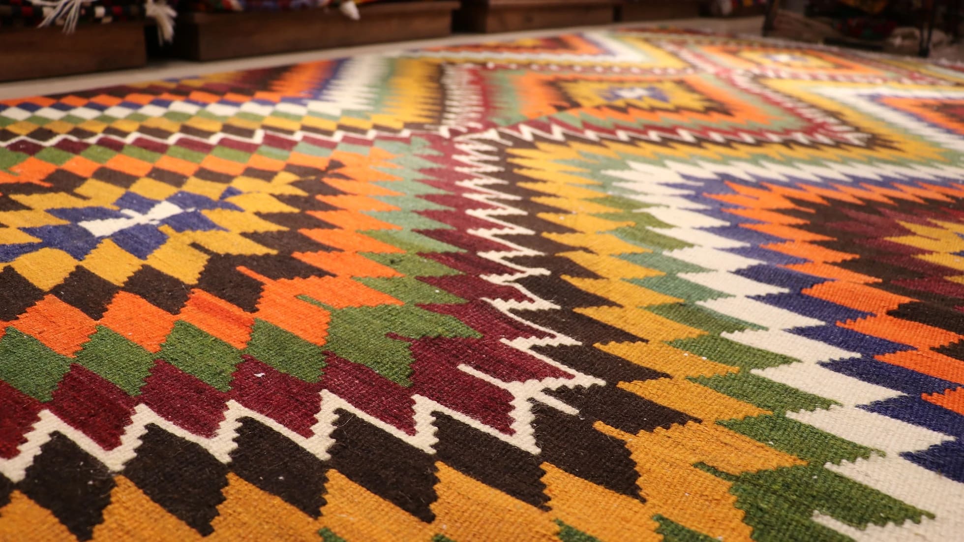 Diamond patterned Turkish kilim rug in orange with tassels in detail
