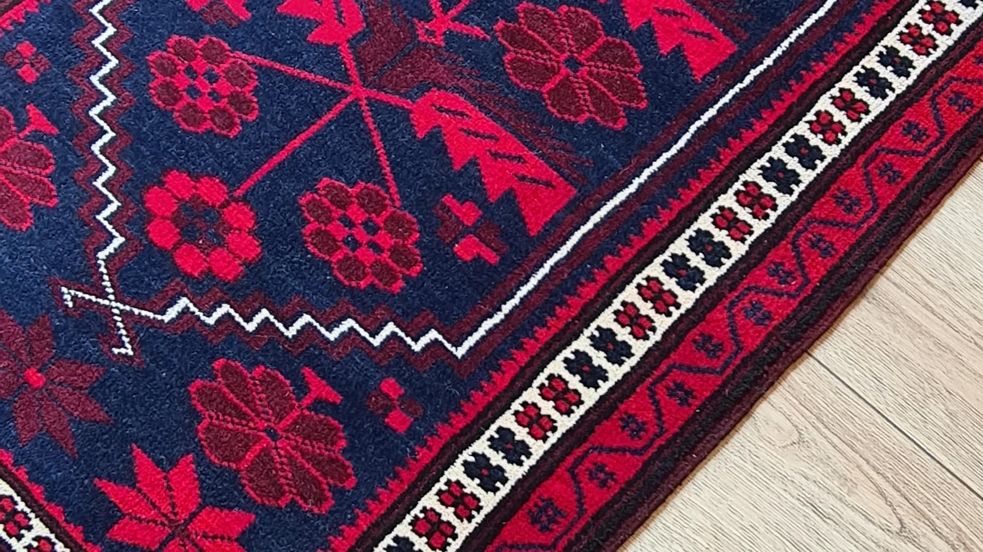 vintage balikesir yagcibedir floral carpet in red and navy hues inside our rug store in NYC