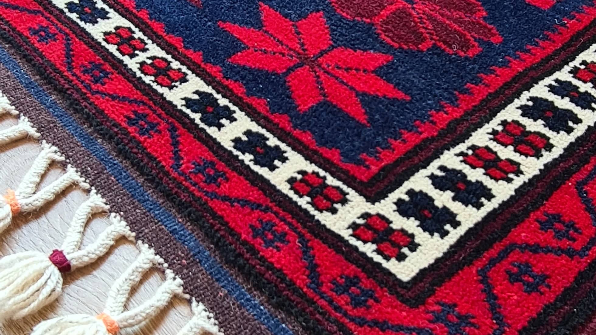 vintage balikesir yagcibedir floral carpet in red and navy hues inside our rug store in NYC