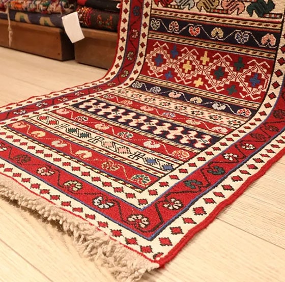 vintage Persian Kurdish wool runner in red with floral patterns and tribal motifs