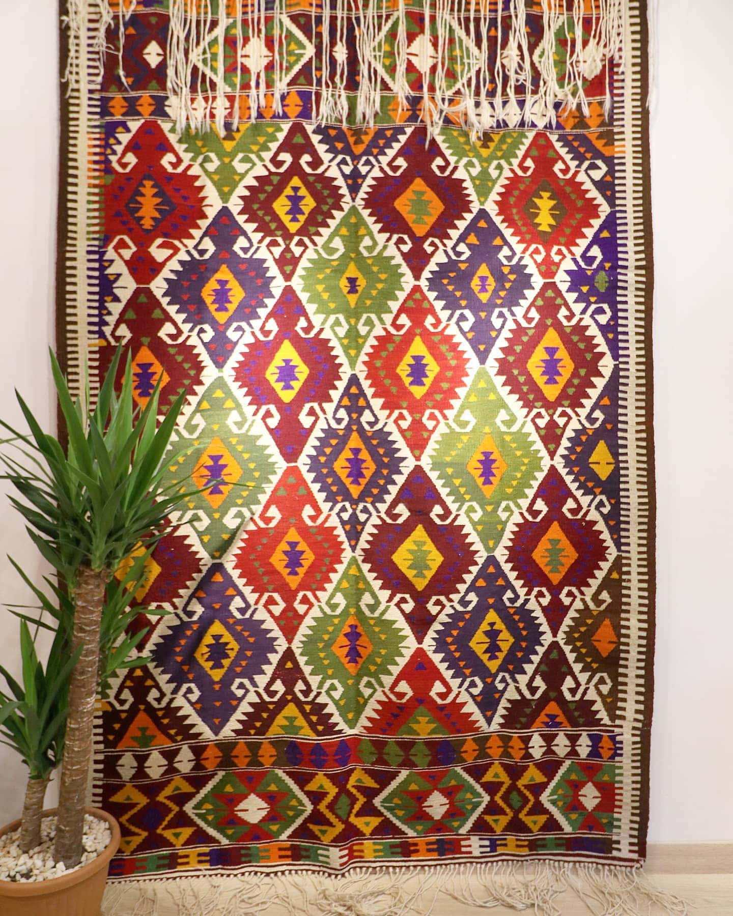 a luxury nomadic handwoven vintage Turkish kilim rug from Antalya in rustic earth tones and tribal motifs