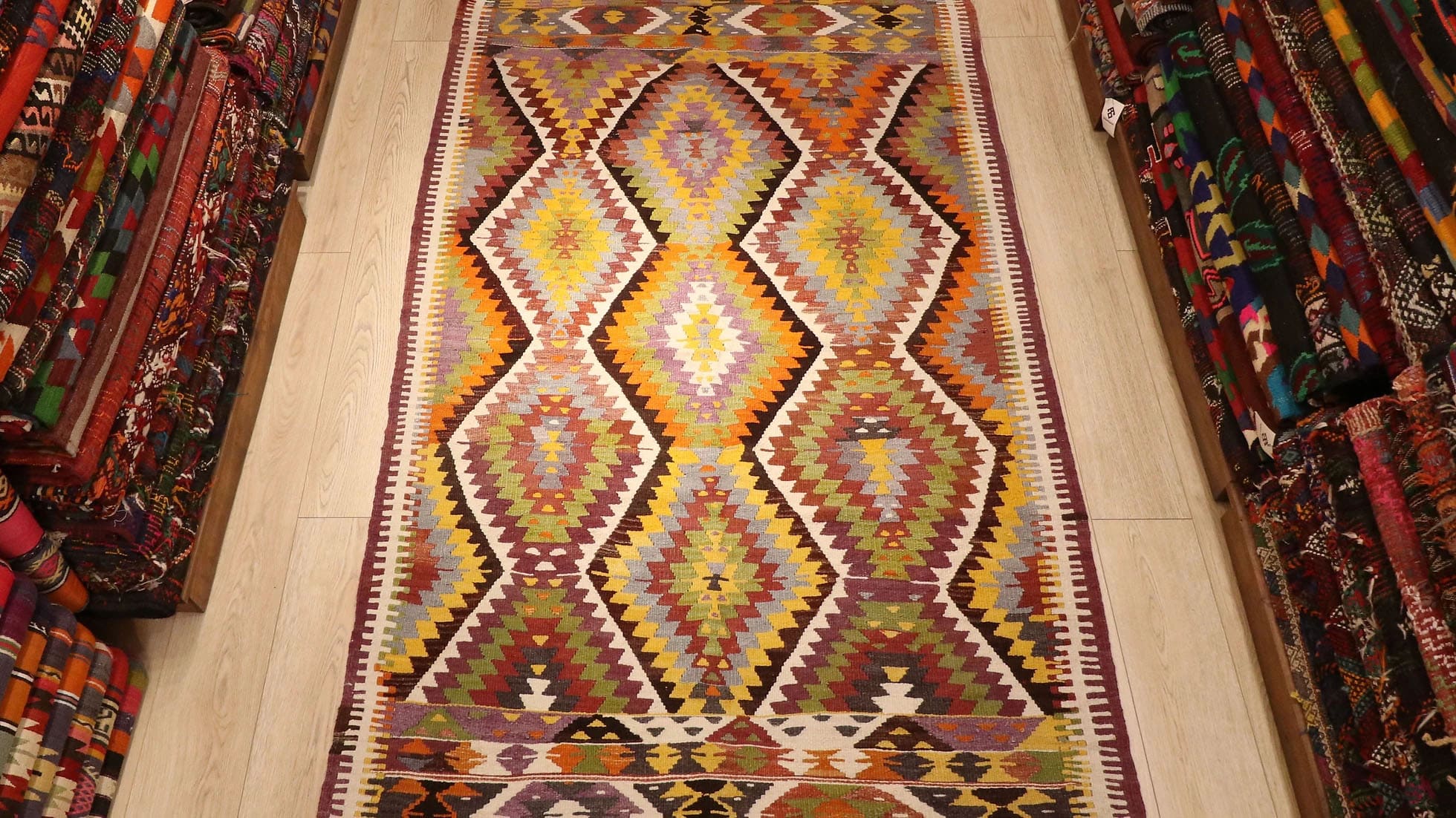 a magnificent Turkish rustic kilim rug in muted pastel tones and tribal patterns by Kilim Couture New York rug showroom