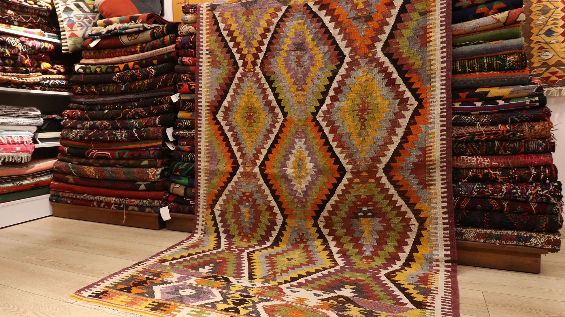 a magnificent Turkish rustic kilim rug in muted pastel tones and tribal patterns by Kilim Couture New York rug showroom