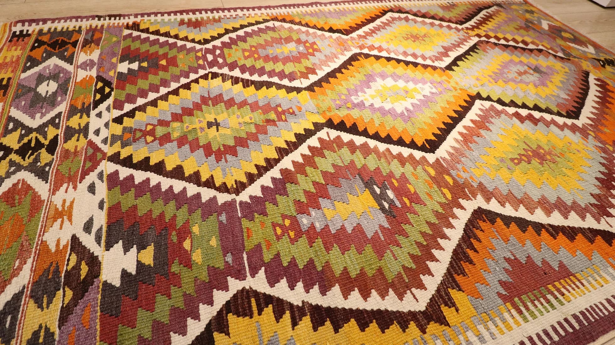 a magnificent Turkish rustic kilim rug in muted pastel tones and tribal patterns by Kilim Couture New York rug showroom