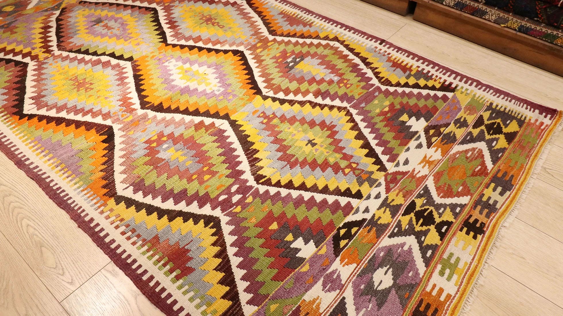 a magnificent Turkish rustic kilim rug in muted pastel tones and tribal patterns by Kilim Couture New York rug showroom