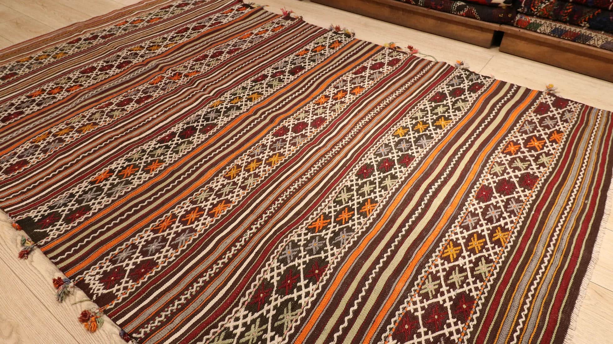 a very rare semi-antique Turkish rug with intricate tassels in rustic, neutral, earthy, and pastel color palette