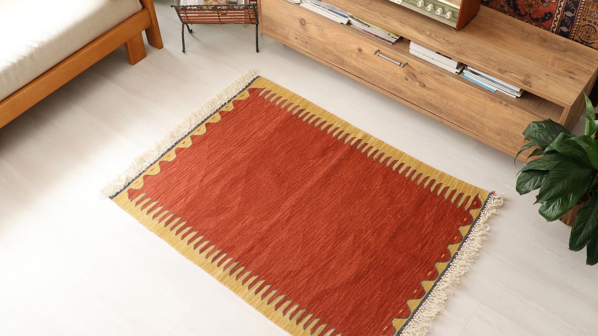 simple and minimal Turkish rug in red and yellow showcasing traditional motifs and white tassels/fringes sourced from the world-renowned city Bodrum