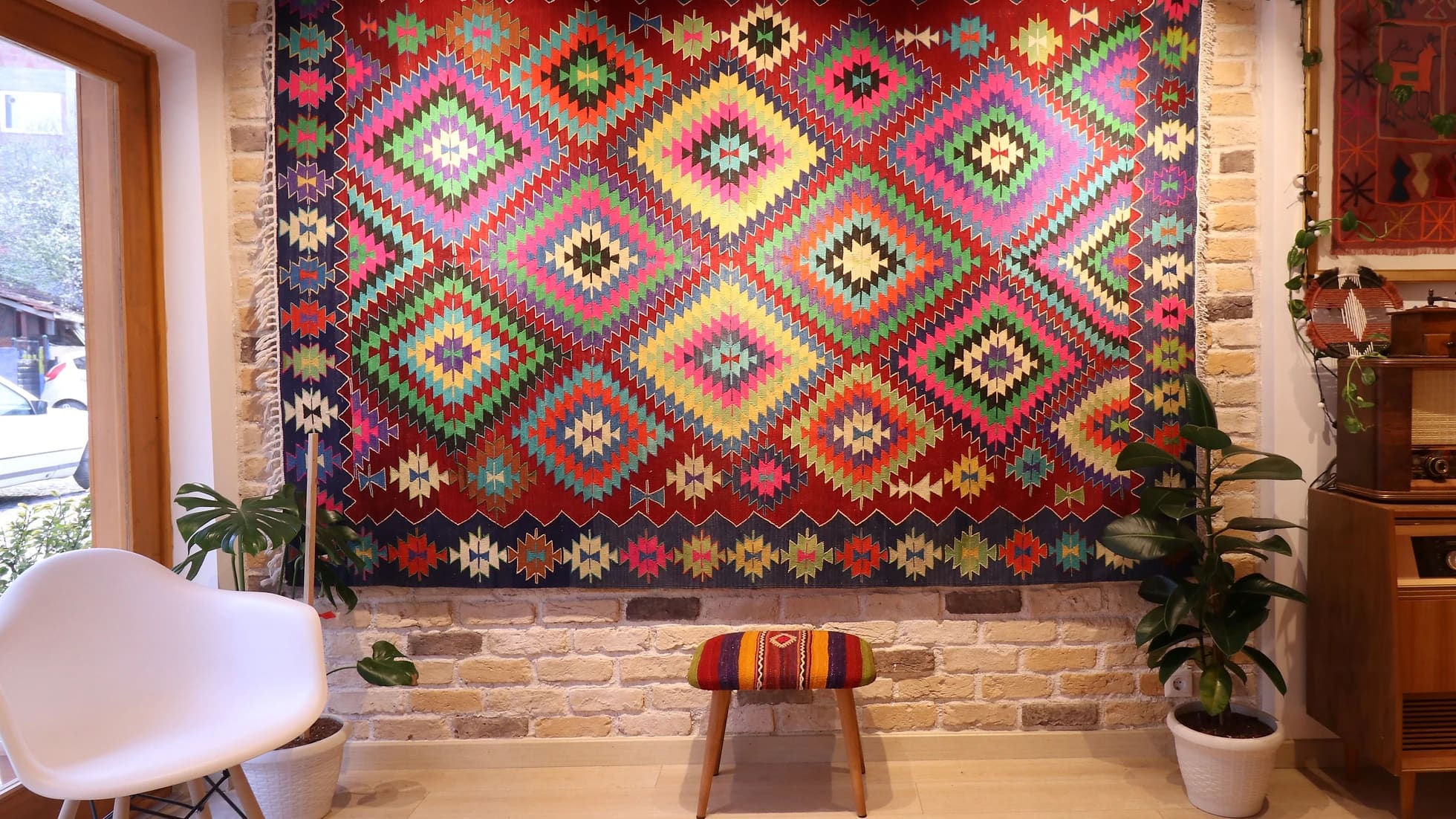 a magnificent and colorful large vintage rug from turkey in traditional motifs and modern style hanging on the wall like a quilt or tapestry