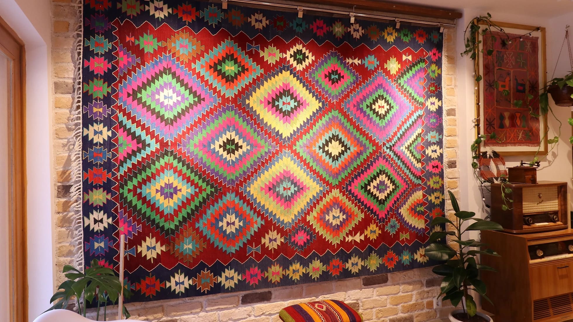 a magnificent and colorful large vintage rug from turkey in traditional motifs and modern style hanging on the wall like a quilt or tapestry