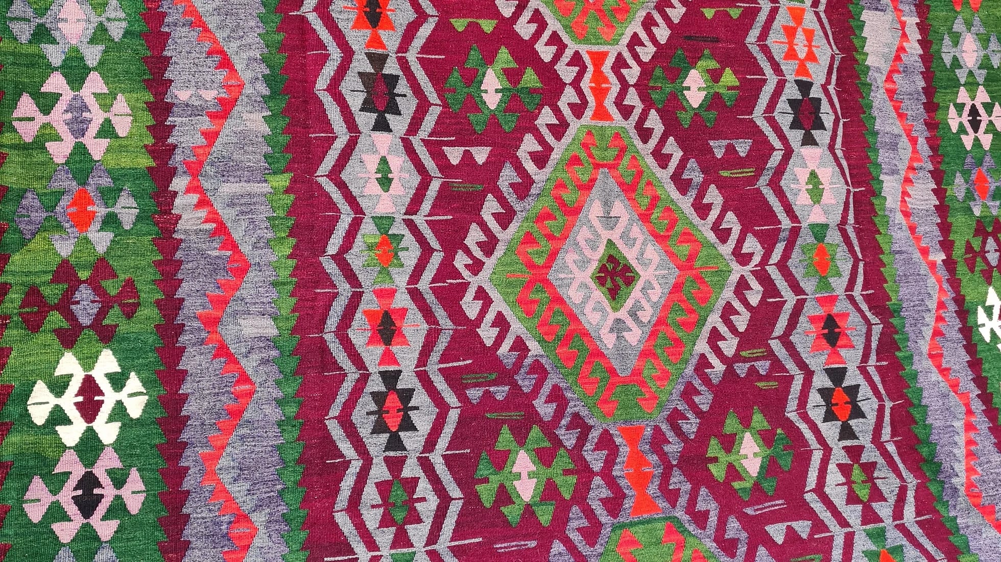 Vintage Handmade Turkish Rug with geometric patterns in red, grey, green in tribal style zoomed