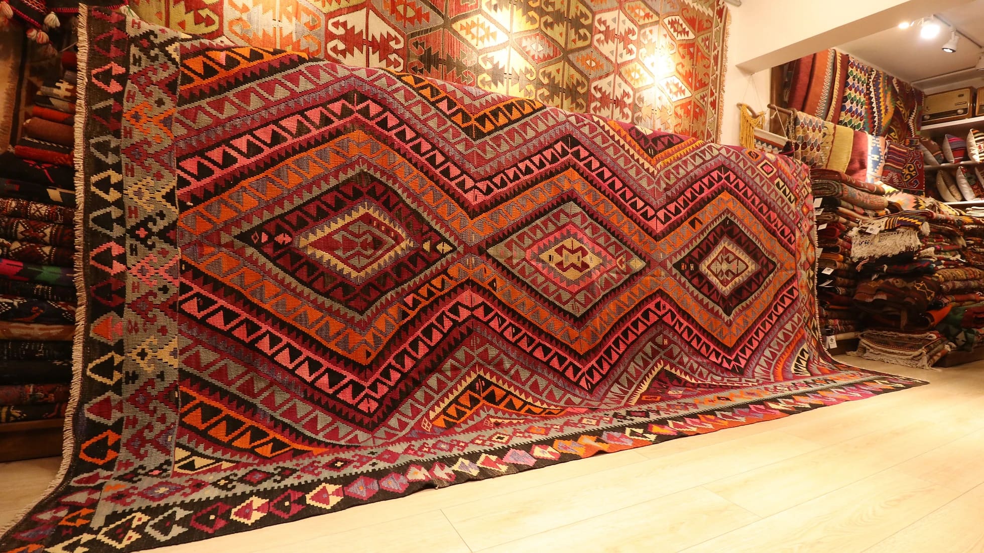 vintage handwoven flat-weave room-sized gallery rug in pastel pink, red, gray, and black with lozenge patterns by Kilim Couture New York