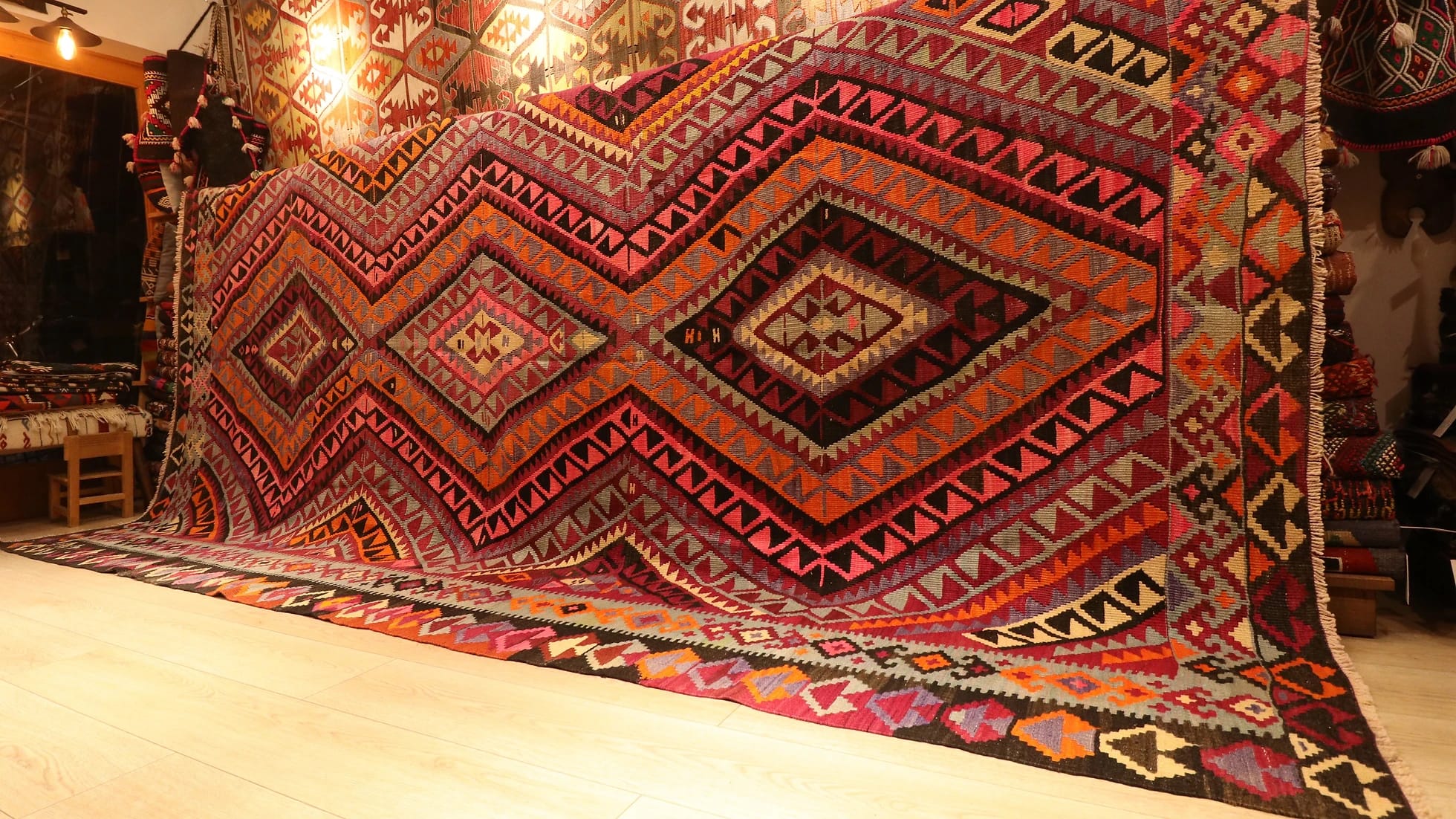 vintage hand-knotted room-sized Turkish rug in pastel pink, red, gray, and black with diamond patterns showcased at our New York rug gallery