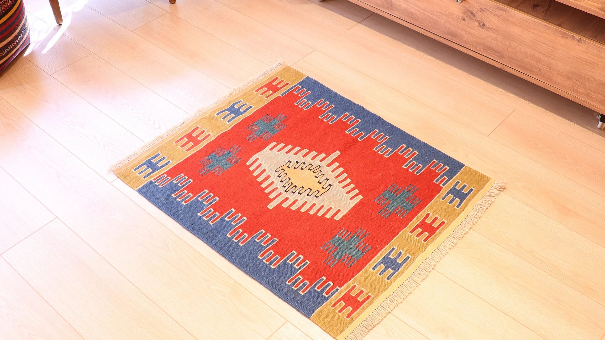 a small and captivating Ushak kilim rug in red, blue, and gold by Kilim Couture New York