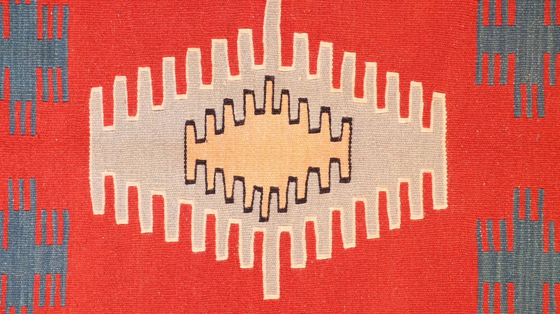 details of the intricate motifs of a small and captivating Ushak kilim rug in red, blue, and gold by Kilim Couture New York
