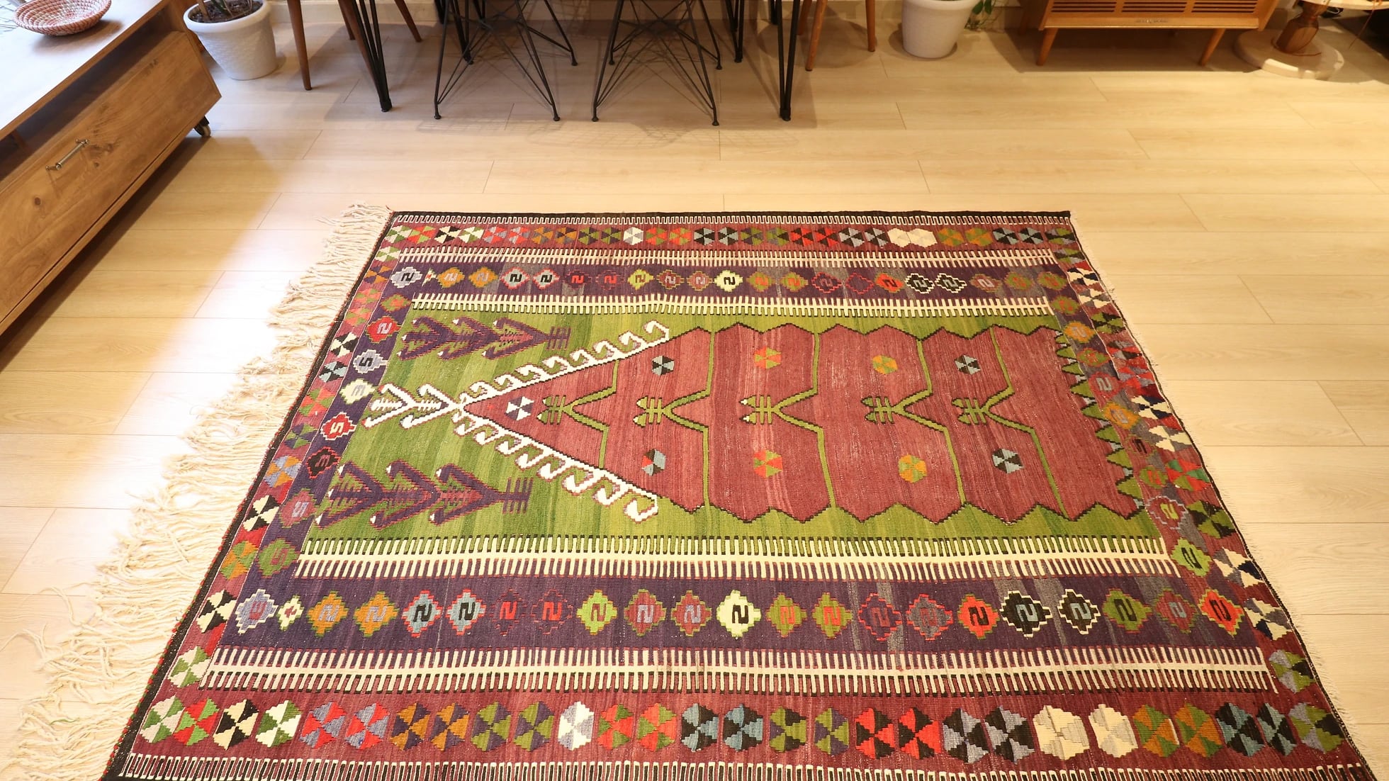 medium-sized handwoven Konya prayer rug with long white fringes featuring many traditional motifs and rustic colors