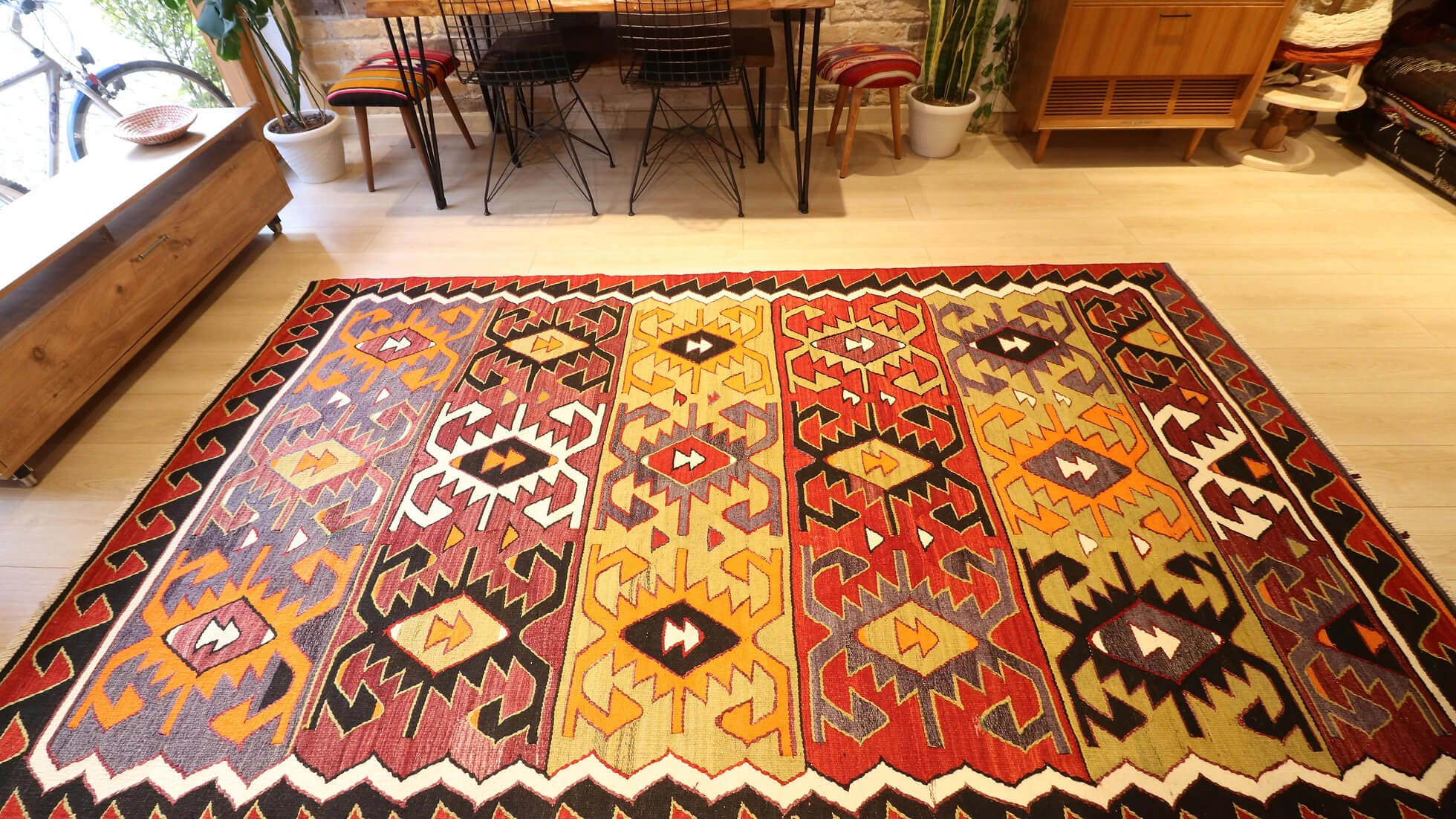 traditional hand-knotted Turkish rug from mid-century in red, black, green, and purple with geometric patterns
