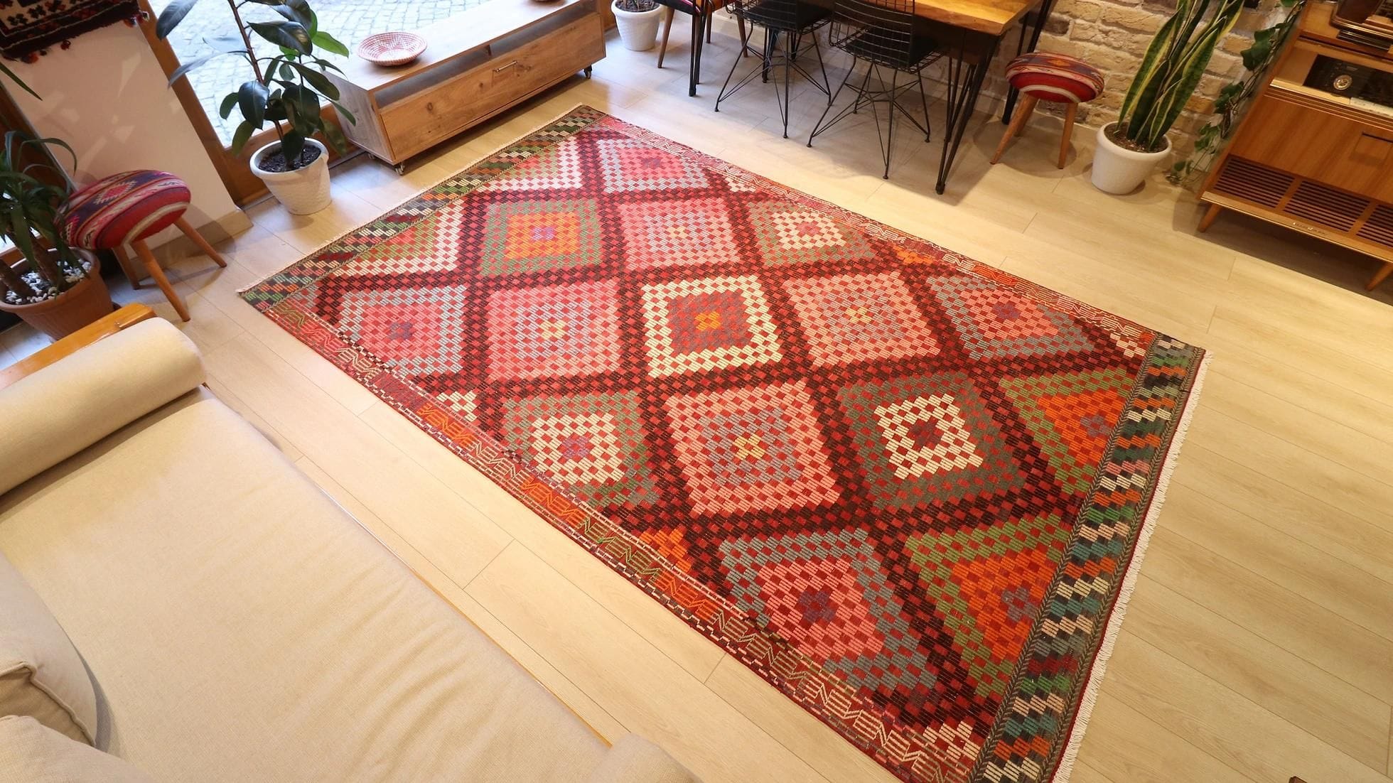 vintage handwoven Turkish wool rug in pastel pink, green, orange, blue, and purple tribal diamond patterns