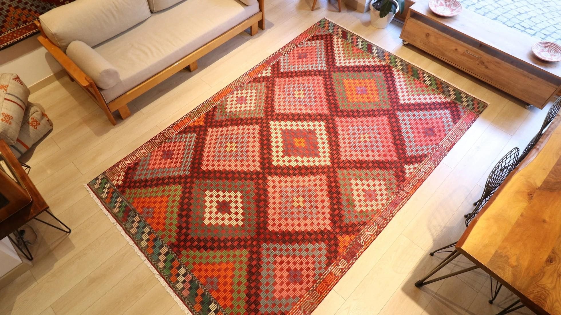 vintage handwoven Turkish wool rug in pastel pink, green, orange, blue, and purple tribal diamond patterns
