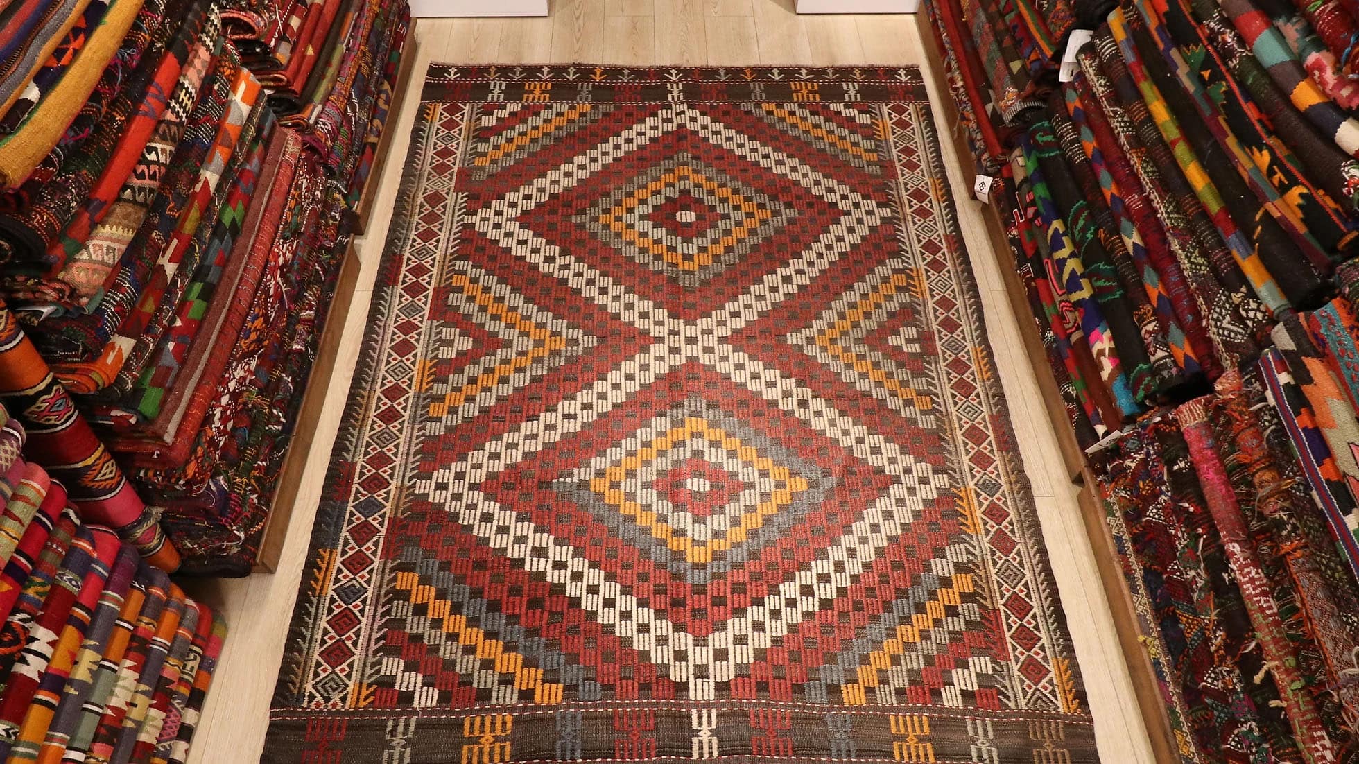 a majestic rustic and pastel cecim rug from Manisa in red, orange, blue, and beige lozenges