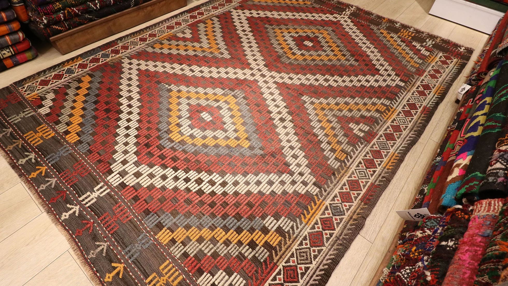 a majestic rustic and pastel cecim rug from Manisa in red, orange, blue, and beige lozenges