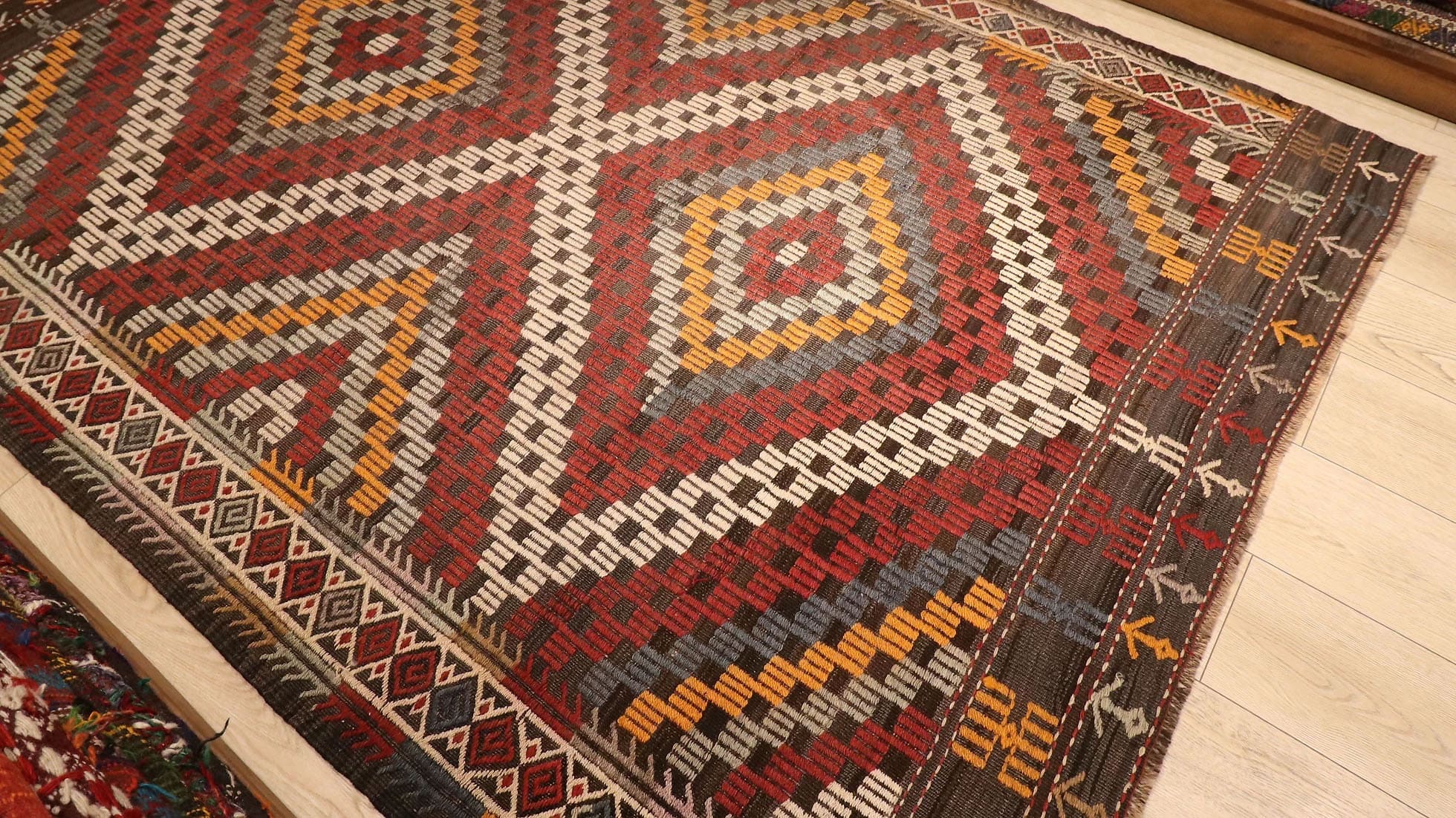 a majestic rustic and pastel cecim rug from Manisa in red, orange, blue, and beige lozenges