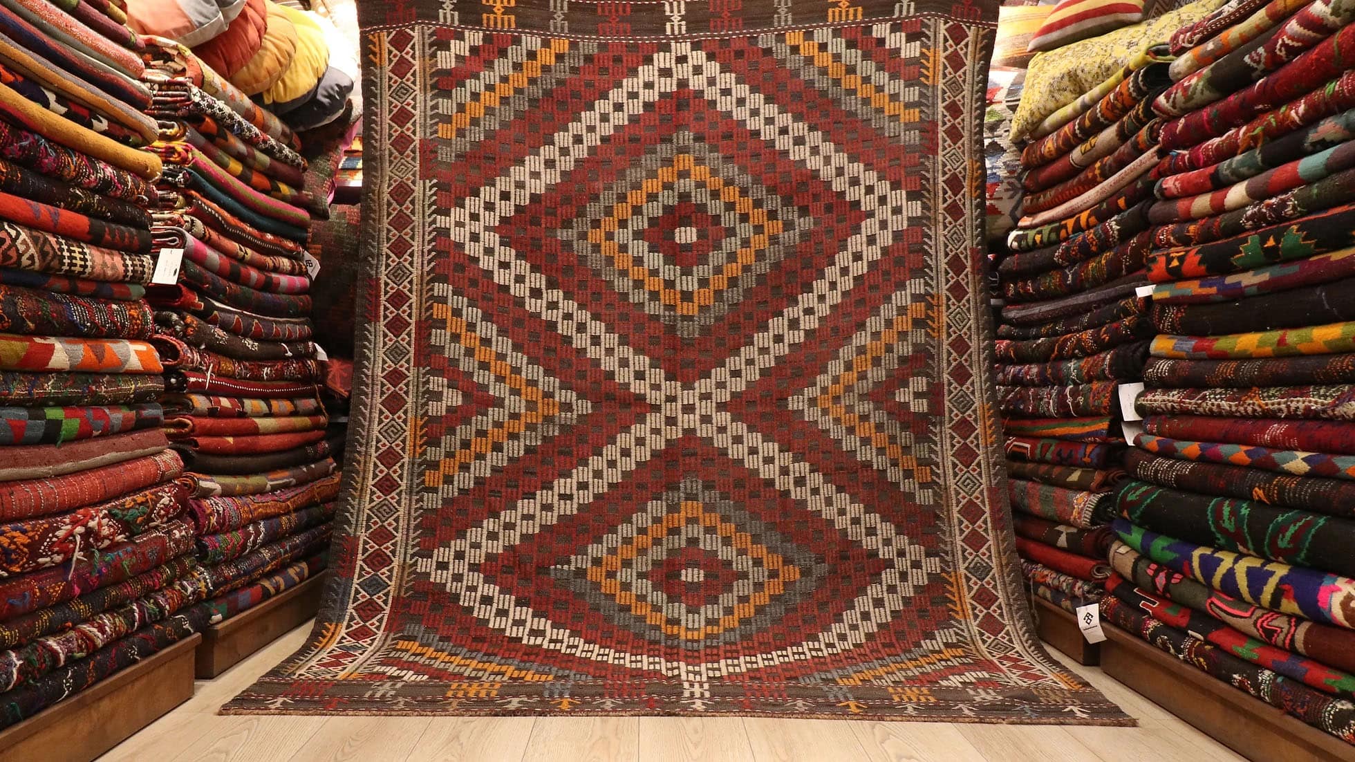 a majestic rustic and pastel cecim rug from Manisa in red, orange, blue, and beige lozenges