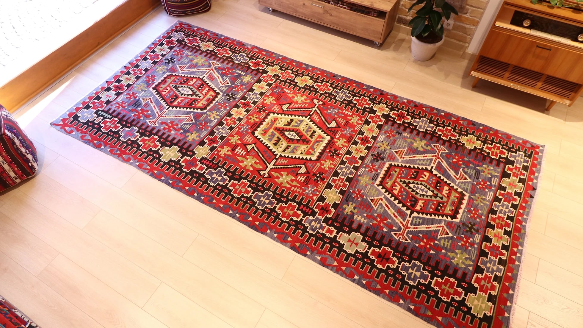 a rustic nomadic Turkish Esme Oushak Rug in many traditional motifs and earthy tones from the mid-century in a NYC rug gallery